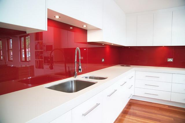 This red glass kitchen splashback gives a prestige feel to the kitchen.